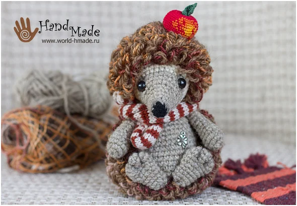 Crochet hedgehog wearing a red and white striped scarf.