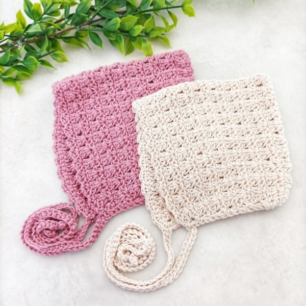 Pink and white crochet baby bonnets.