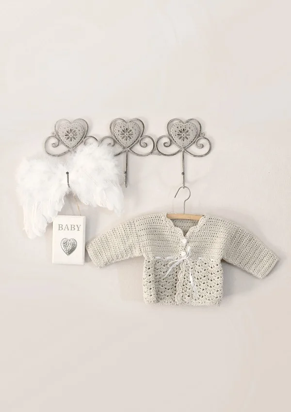 Off-white crochet baby cardigan on clothes hanger.