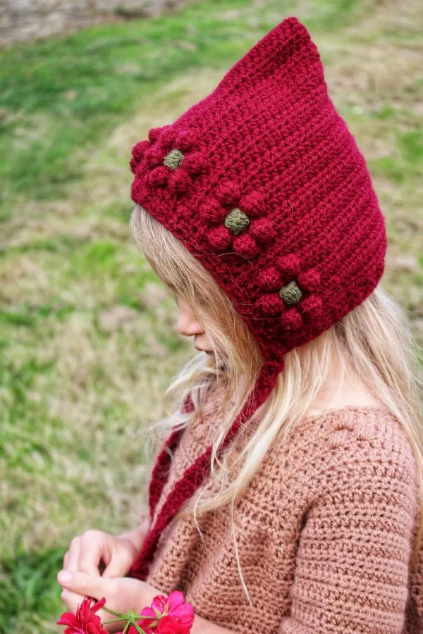 Child wearing red crochet pixie bonnet