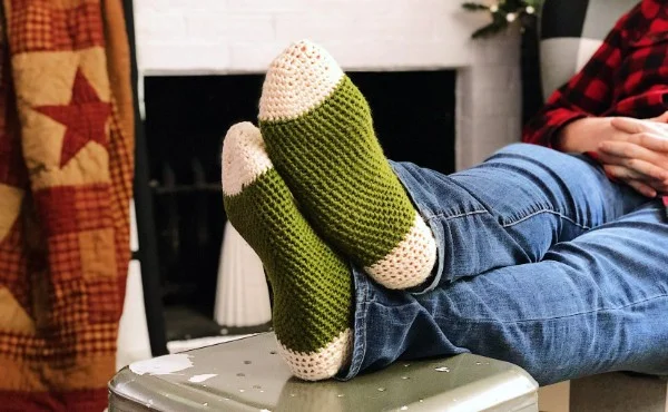 Mna wearing green crochet slipper socks.