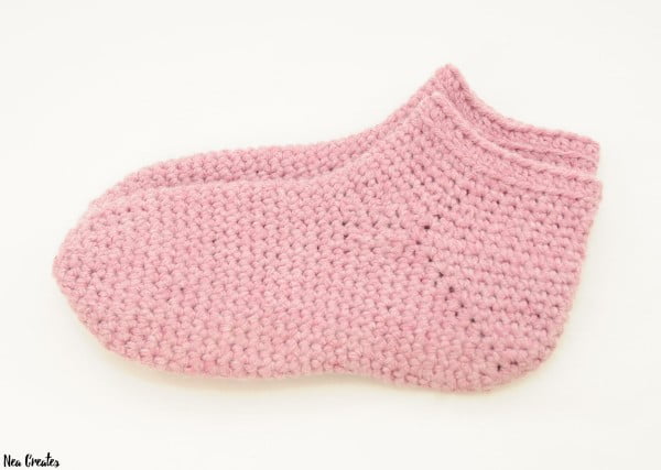 A pair of pink crochet slipper socks.