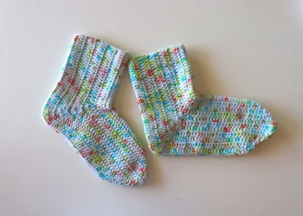 Crochet socks in multicoloured yarn.