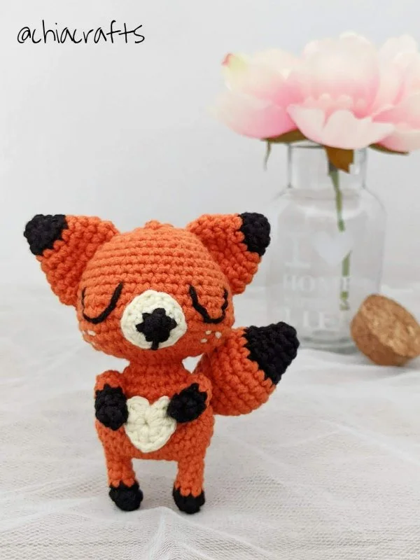 Crochet fox with a heart shape on its belly.