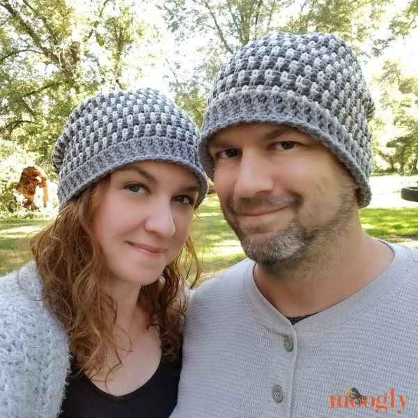 A man and a woman wearing matching crochet hats.