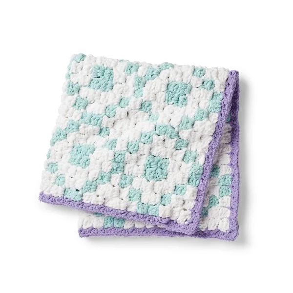 Folded crochet blanket with geometric pattern.