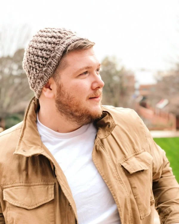 Side profile of a man wearing a crocheted beanie.