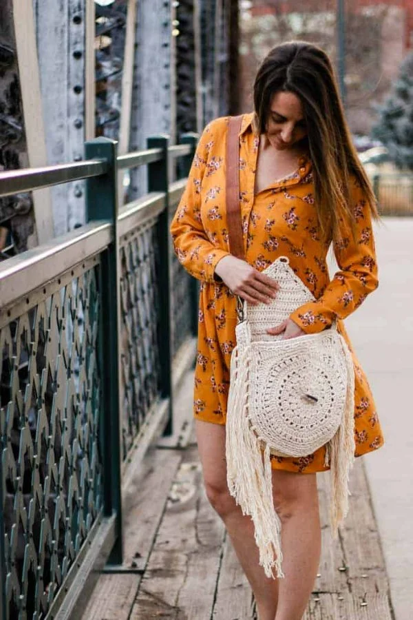 Crochet bag wth tassels and woman in orange dress.