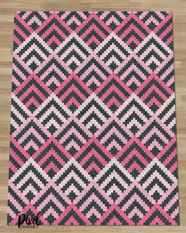 A crochet C2C blanket in pink and black.
