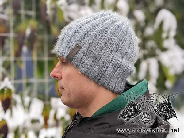 Side profile of a man wearing a grey ribbed beanie.