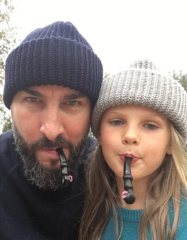 A man and a child in matching crochet hats.