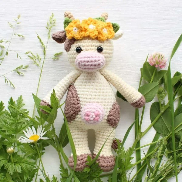 A cow plushie with a flower headband.