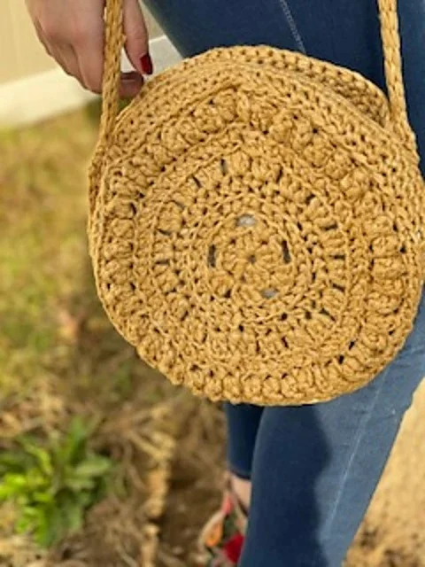 Close up of a yellow crochet circle bag.