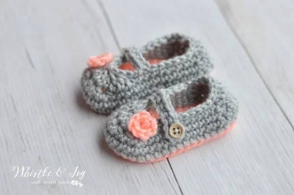 Grey and peach-coloured crochet mary jane baby shoes.