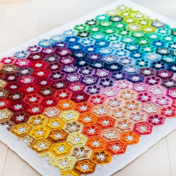 Rainbow-coloured crochet hexagon baby blanket.