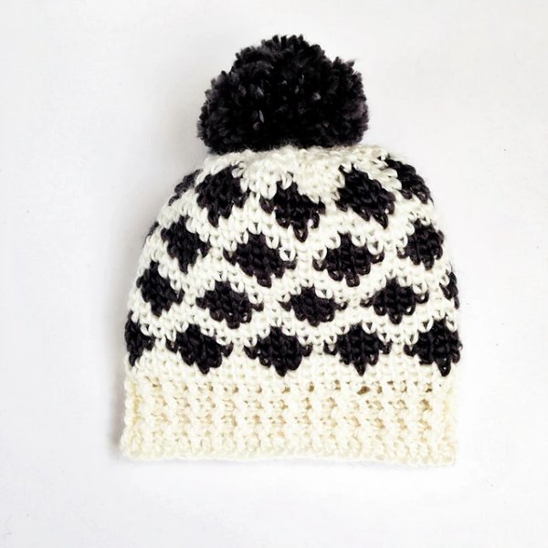 A black and white Ikat colourwork crochet hat.