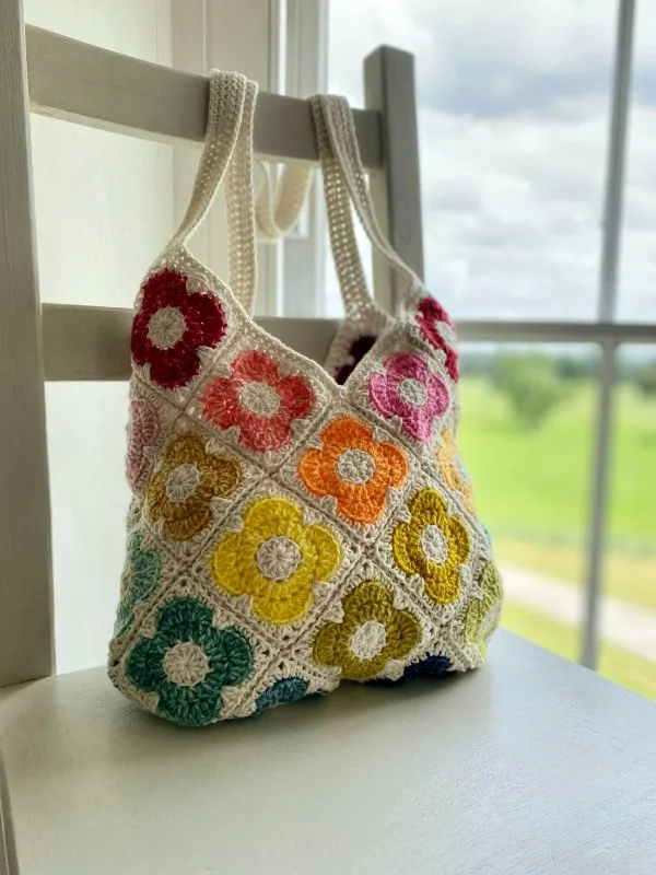 Vintage-style flower granny square bag on a chair.