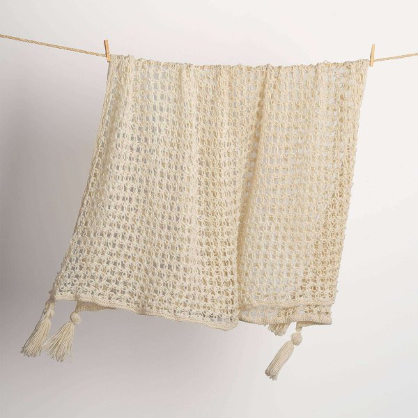 Cream-coloured c2c crochet blanket hanging on a line with wooden pegs.