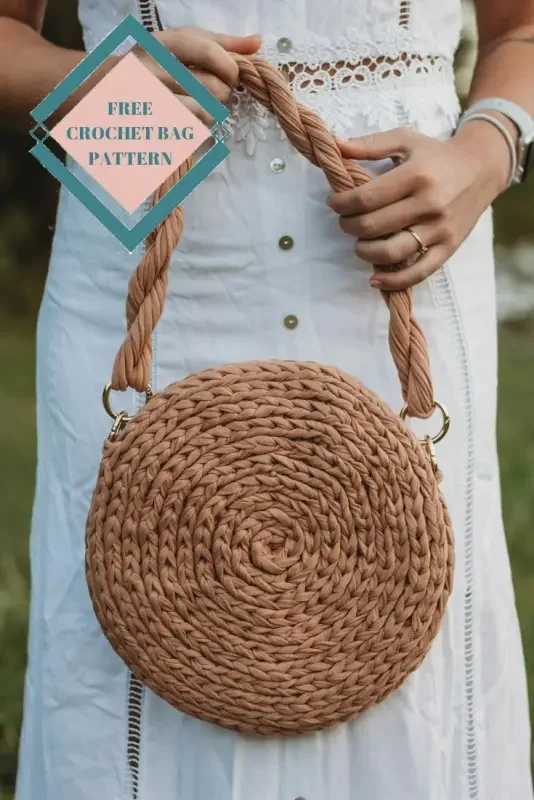 closeup of a woman holding a brown crochet bag with twisted strap.