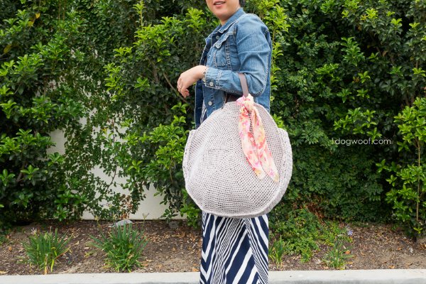 Large crochet circle bag hanging off woman's arm.