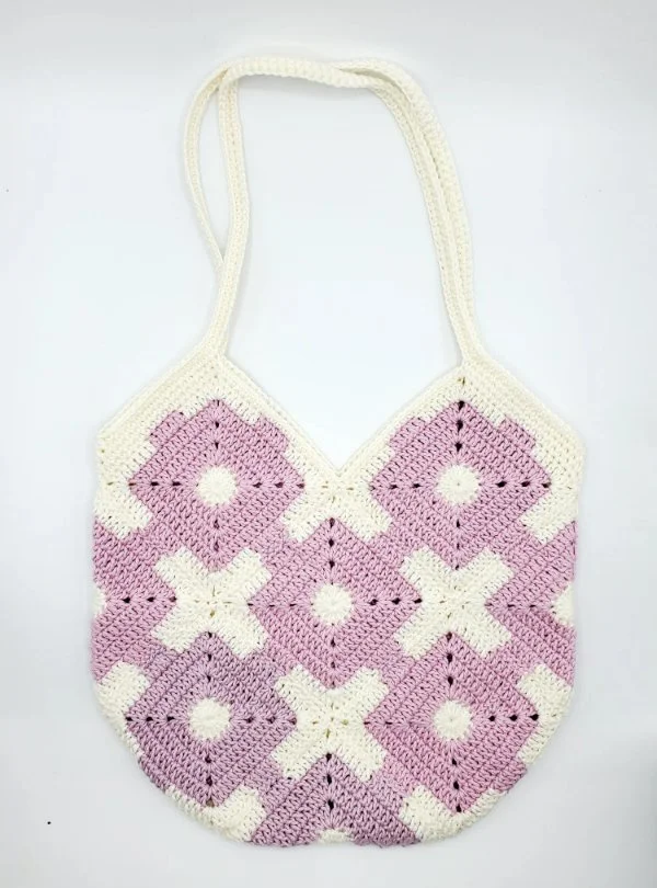 A pink and white crochet granny square bag.