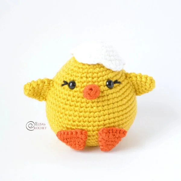 A crochet chick with an eggshell hat.