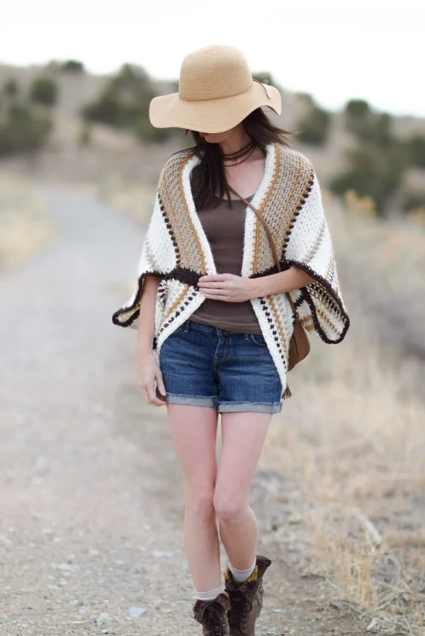 A  woman wearing a boho-style striped crochet shrug.