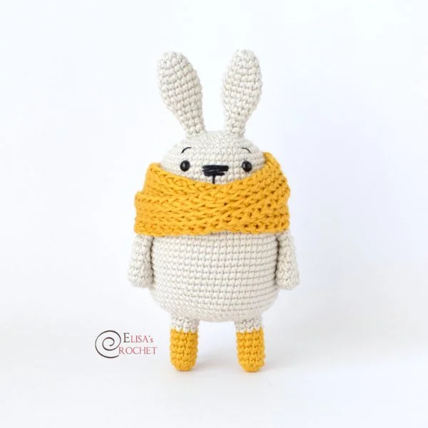 A white crochet rabbit in a yellow scarf and boots.