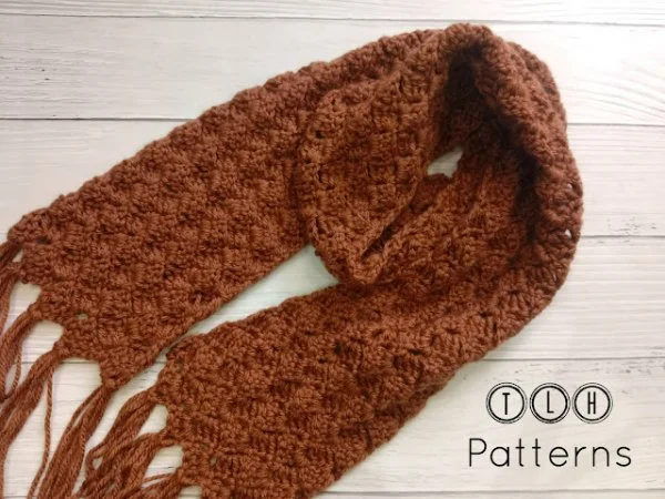 A rust-coloured crochet scarf for men with fringing.