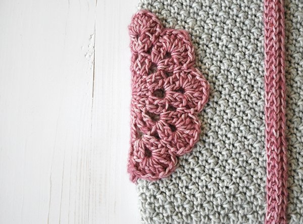 A grey crochet tablet case with pink details.