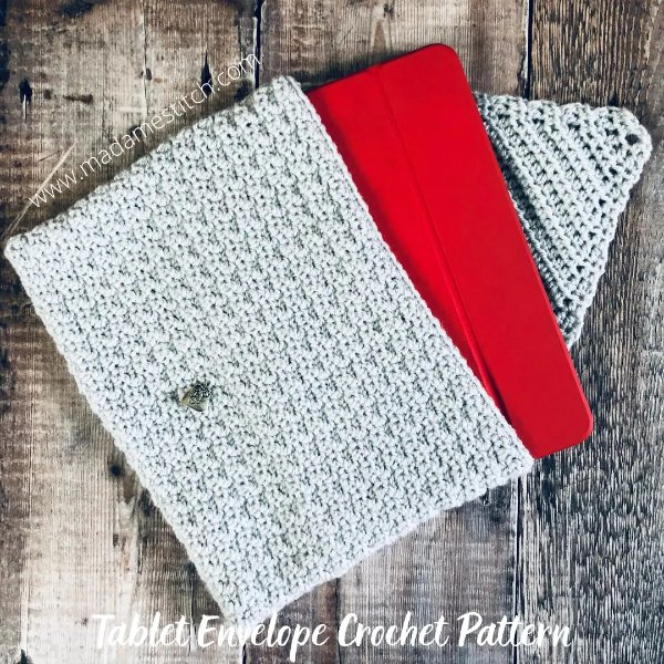 A crochet iPad case on a timber background.