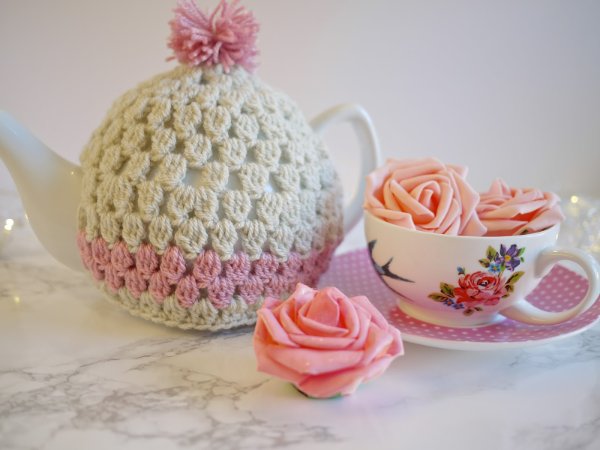 Pink granny stitch crochet tea cozy and tea cup.