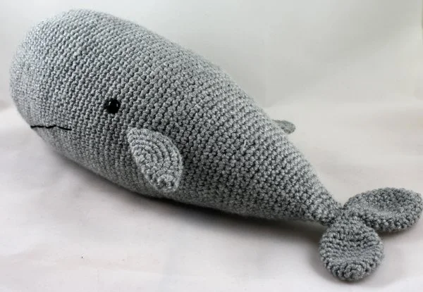 A large grey crochet Sperm Whale plushie.