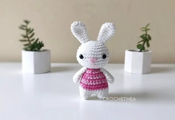 Amigurumi bunny in a pink top.