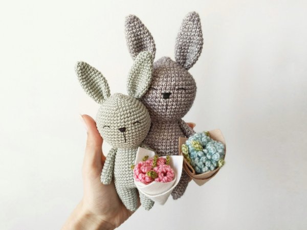 Crochet rabbits holding bunches of flowers.