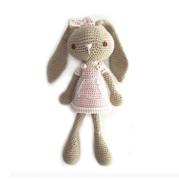 A crochet bunny in a pink dress with long ears and long legs.