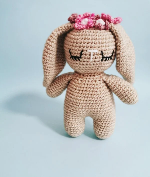 A crochet bunny wearing a flower crown.