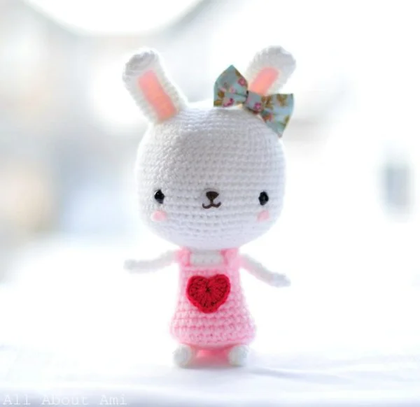 A white crochet rabbit in a pink love heart dress.