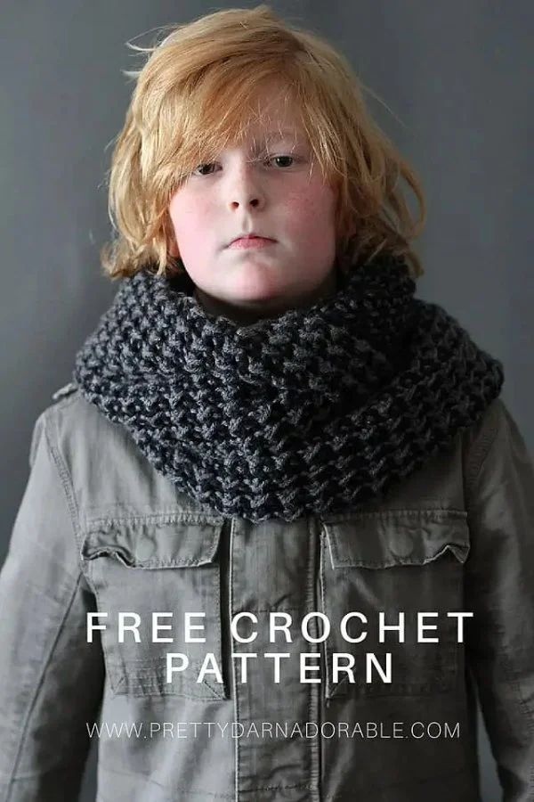 A boy wearing a charcoal coloured crochet cowl.