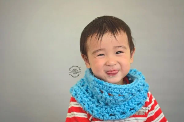 A child in a bright blue crochet cowl.