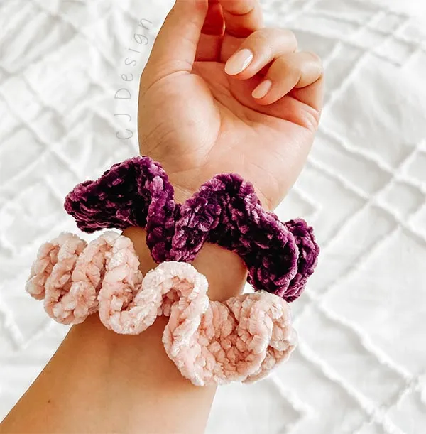 Two crochet scrunchies on a wrist.