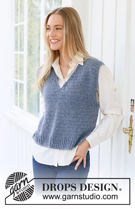 a woman wearing a grey-blue crochet sweater vest with a v-neck.