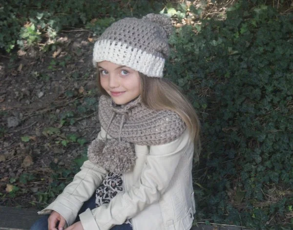 A girl in a garden with a matching crochet cowl and beanie.