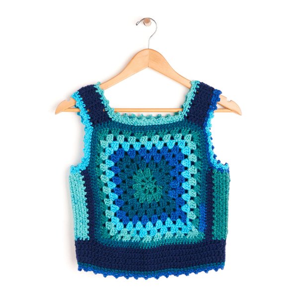 A retro granny square crochet sweater vest in bright blues.