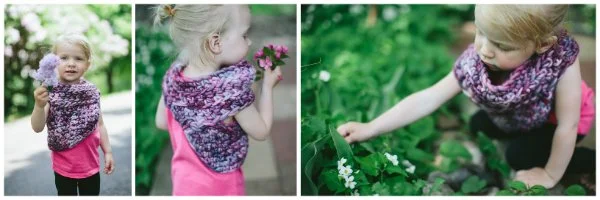 A child in a garden wearing a crochet cowl.