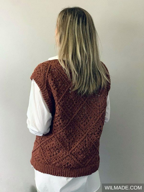 A back view of a woman in an oversized crochet sweater vest.