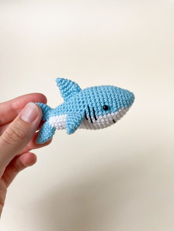 A blue and white crochet baby shark.