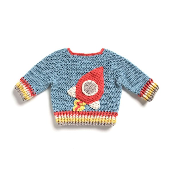 A crochet baby sweater with rocket applique on a white background.