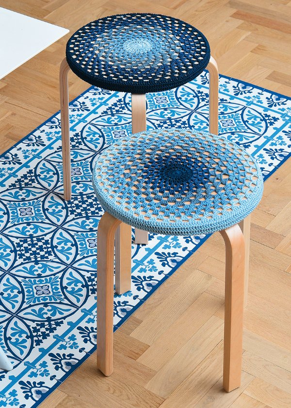 Two stools covered in bright blue crochet stool covers.