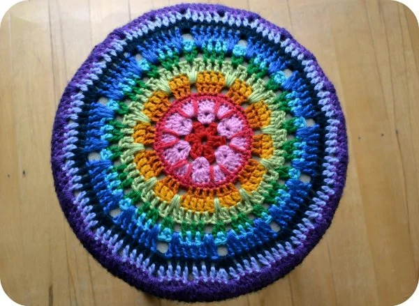 A top view of a crochet stool cover mandala.